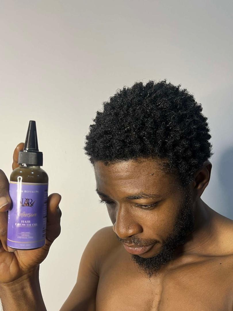 Man holding IAR hair growth oil bottle, showing the product in use